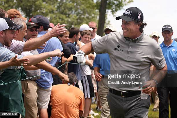 Phil Mickelson is greeted by golf fans during the continuation of the first round of the 109th U.S. Open on the Black Course at Bethpage State Park...