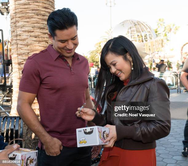 Kelly Marie Tran signs a Funko Pop at "Extra" at Universal Studios Hollywood on December 4, 2017 in Universal City, California.