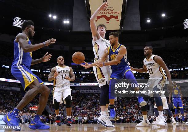 Stephen Curry of the Golden State passes around Omer Asik of the New Orleans Pelicans during the second half of a game at the Smoothie King Center on...