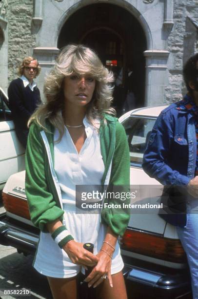 American actress Farrah Fawcett poses with a tennis racket outside the Playboy Mansion where she participated in a charity tennis match, Los Angeles,...