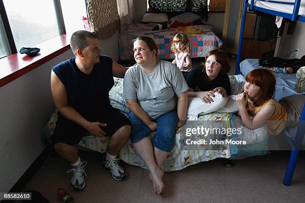 Brian and Julie Morris sit with their three daughters in their room at the Family Gateway homeless shelter on June 18, 2009 in Dallas, Texas. Julie...