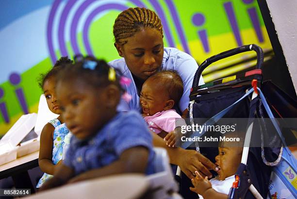 Jennifer Ross, living in a homeless shelter with her five children, holds one child while feeding another on June 18, 2009 in Dallas, Texas. Ross...