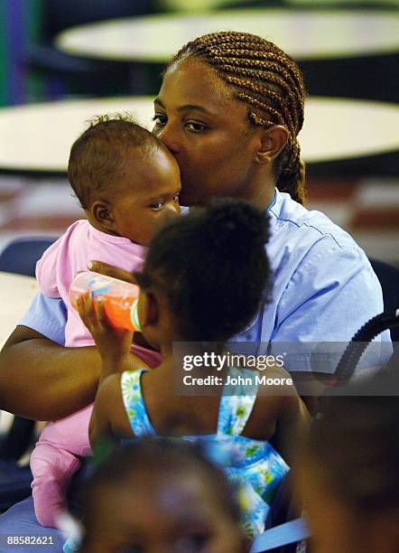 Jennifer Ross, living in a homeless shelter with her five children, holds Shamyrii Roberts, age 4 months, after receiving a free dinner on June 18,...