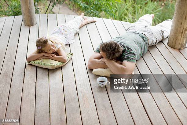 father and daughter laying on porch - coffee on patio stock pictures, royalty-free photos & images