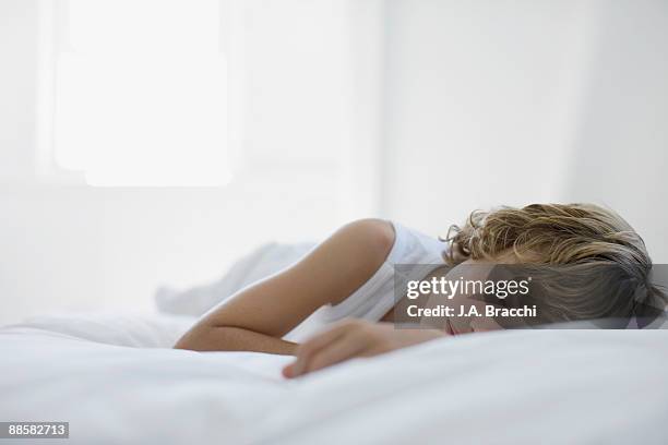 boy sleeping on bed - sleeping boys stockfoto's en -beelden