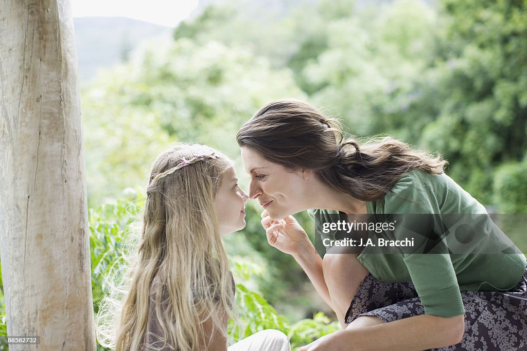Mother giving daughter eskimo kiss outdoors