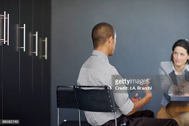 businessman talking to co-worker in office - intervista foto e immagini stock