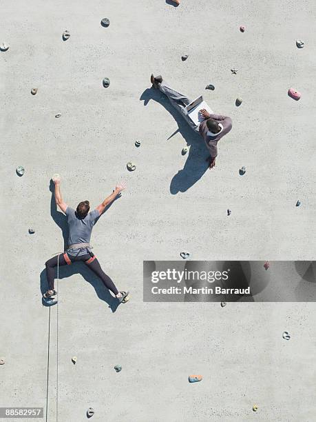 businessman using laptop on rock climbing wall - rock face stock pictures, royalty-free photos & images