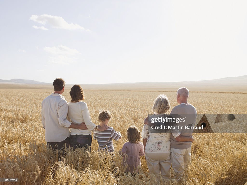 Family hugging in remote wheat field