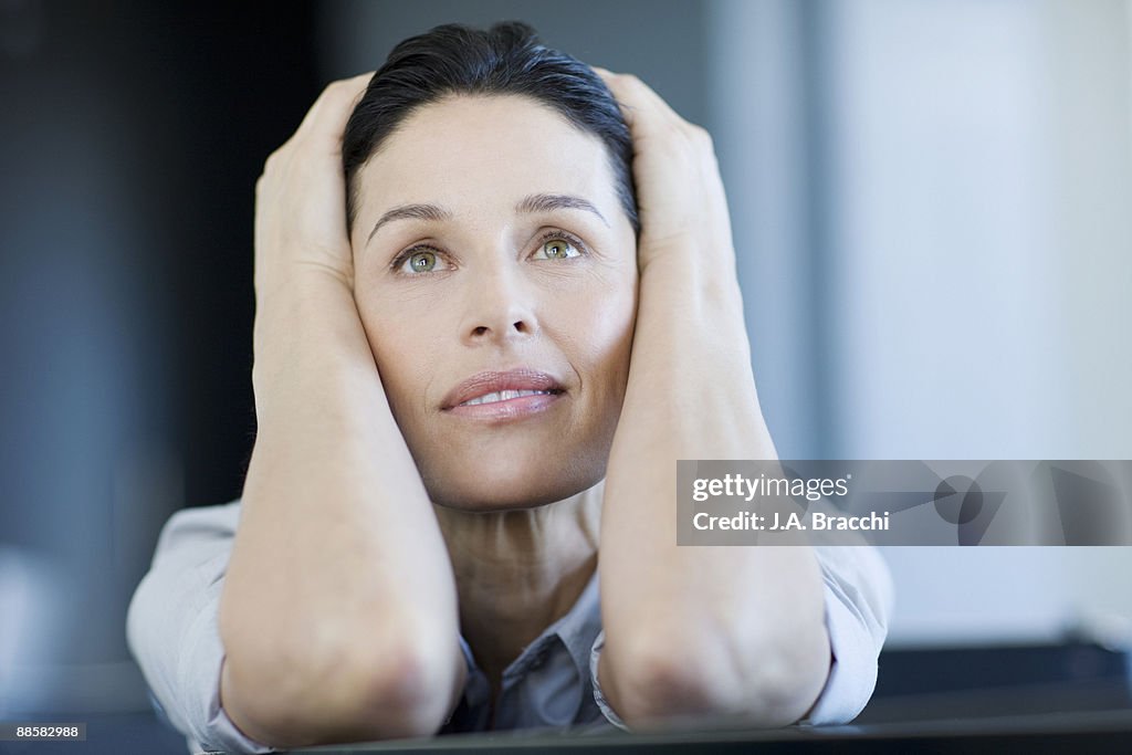 Stressed businesswoman with head in hands