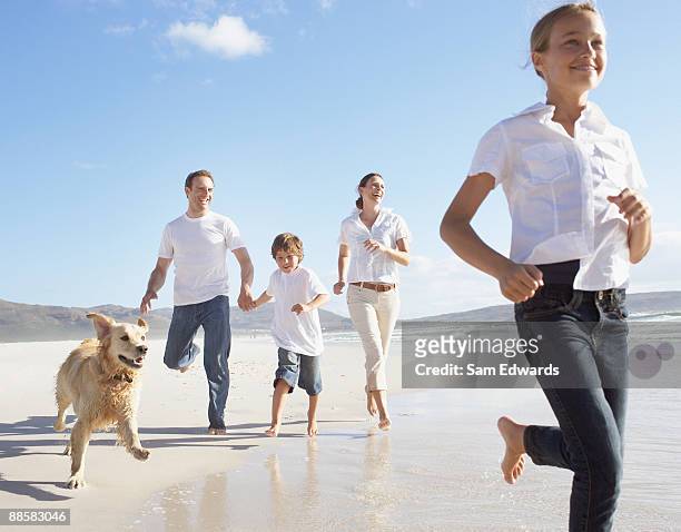 family running on beach - family with two children stockfoto's en -beelden