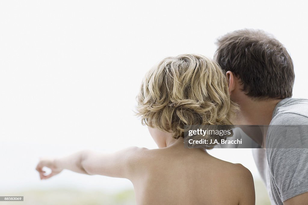 Boy pointing out something to father