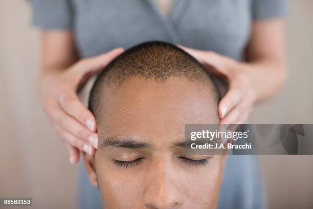 woman rubbing mans head - man massage stock pictures, royalty-free photos & images