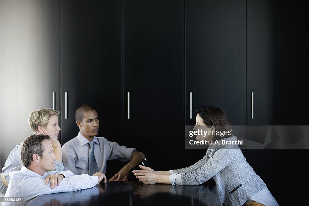 Businesswoman talking to co-workers in conference room