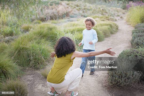 boy running to mother on trail - welcome to los angeles stock pictures, royalty-free photos & images