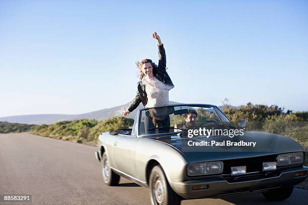 coppia guida in cabriolet - three quarter length foto e immagini stock