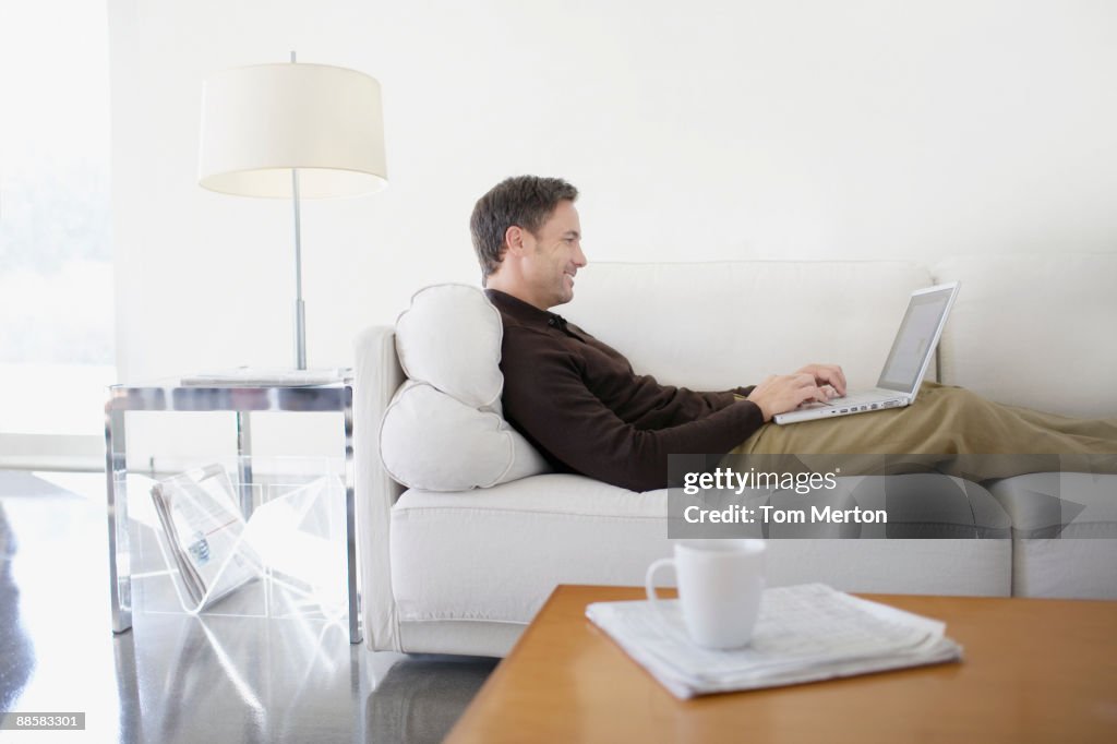 Man using laptop on sofa