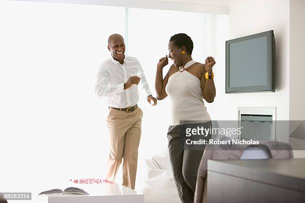 couple dancing in living room - fernseher tanzen home stock-fotos und bilder