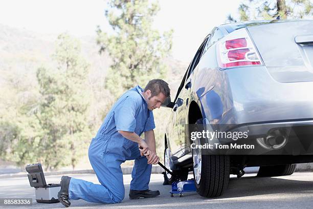 mechanic changing car tire - jack stock pictures, royalty-free photos & images