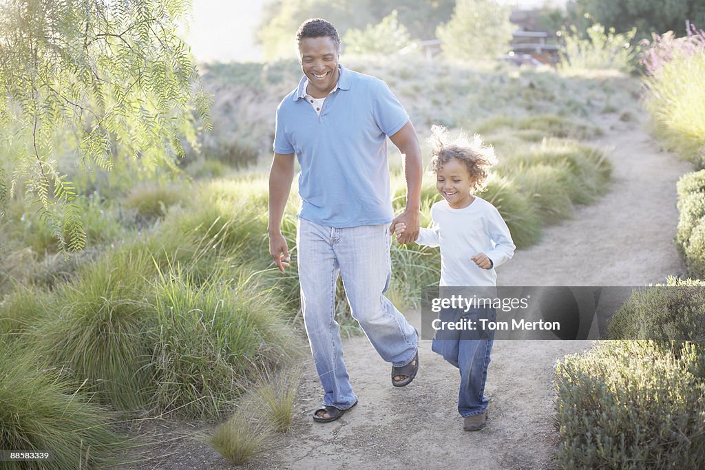 Homem a andar com o filho em percursos de terra