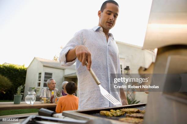 man grilling in backyard - men grilling stock pictures, royalty-free photos & images