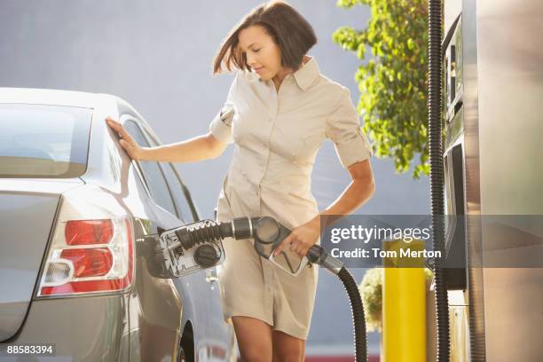 woman pumping gas - filling petrol stock pictures, royalty-free photos & images