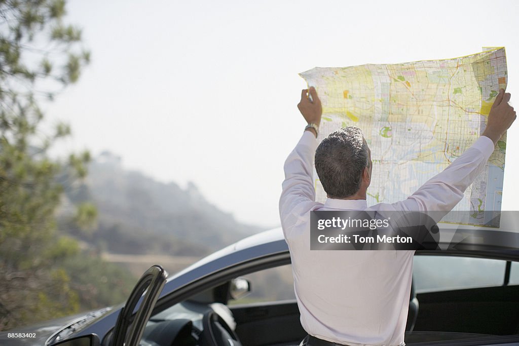 Man looking at map by car