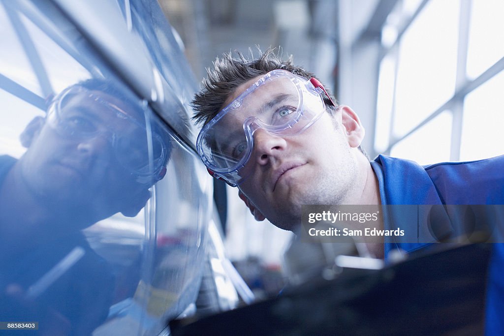 Technician inspecting car