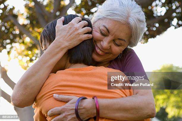 grandmother hugging grandson outdoors - hispanic grandmother stock pictures, royalty-free photos & images