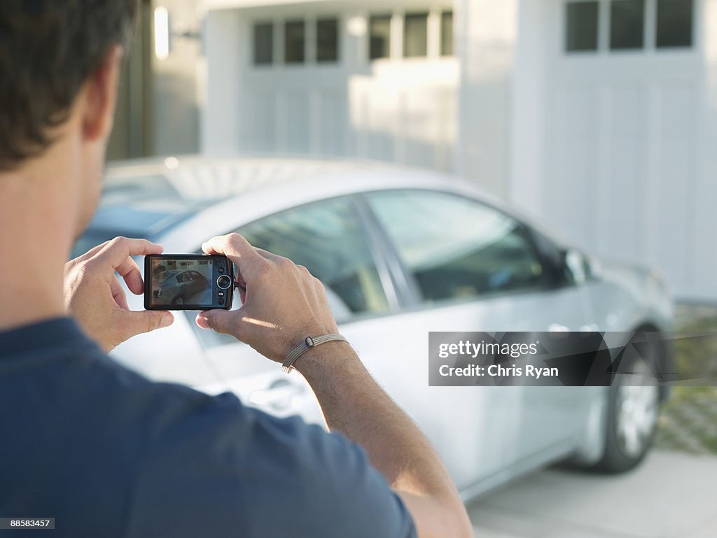 Homem fotografando carro novo