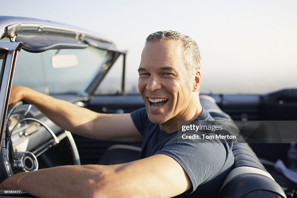 Man driving convertible car