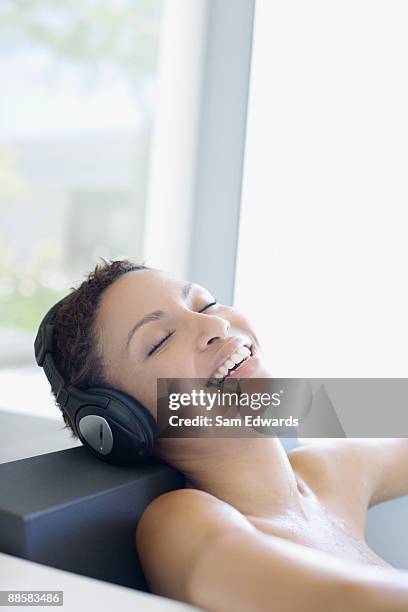 femme écoutant de la musique dans la baignoire - repose tête photos et images de collection