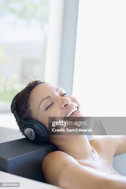 woman listening to music in bathtub - head rest stock pictures, royalty-free photos & images