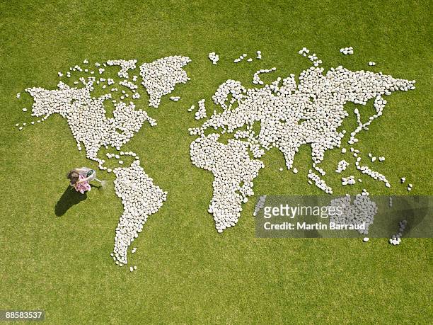 girl watering world map made of rocks - international day one stock pictures, royalty-free photos & images