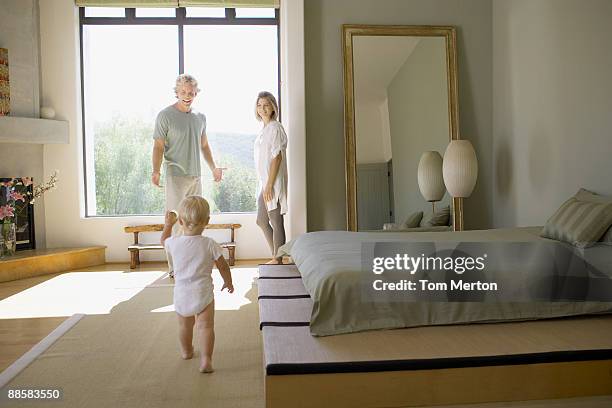 couple and baby in bedroom - modern bedroom stock pictures, royalty-free photos & images