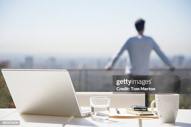 mann nimmt eine pause von der arbeit auf dem balkon - über etwas schauen stock-fotos und bilder