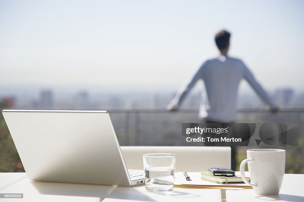 Man taking a break from working on balcony