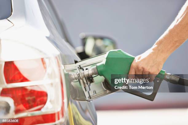 man pumping gas - fossiele brandstoffen stockfoto's en -beelden