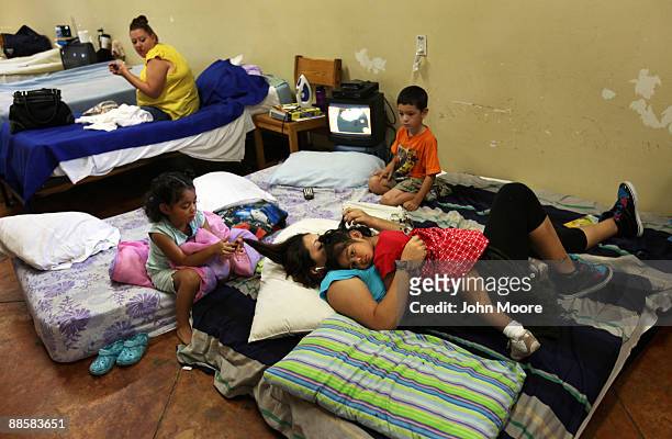 Jo Ann Gonzalez lies with her three children in a common room for recent arrivals to the Presbyterian Night Shelter on June 19, 2009 in Ft. Worth,...