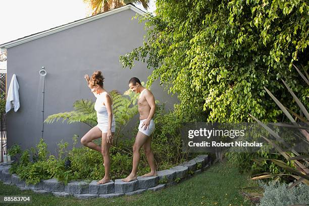 couple walking on low wall in backyard - moving after - fotografias e filmes do acervo