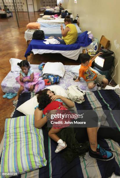 Jo Ann Gonzalez lies with her three children in a common room for recent arrivals to the Presbyterian Night Shelter on June 19, 2009 in Ft. Worth,...
