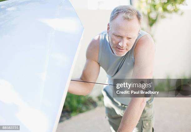 man checking oil in car - dipstick stock pictures, royalty-free photos & images
