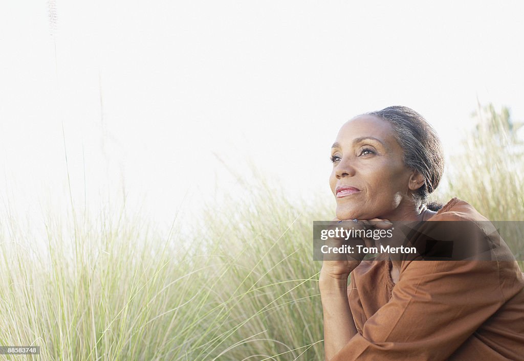 Serene woman sitting in sunny field