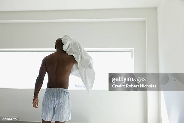 man drying head in bedroom - mens shorts stock pictures, royalty-free photos & images