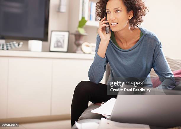 woman talking on cell phone at home - answering stock pictures, royalty-free photos & images