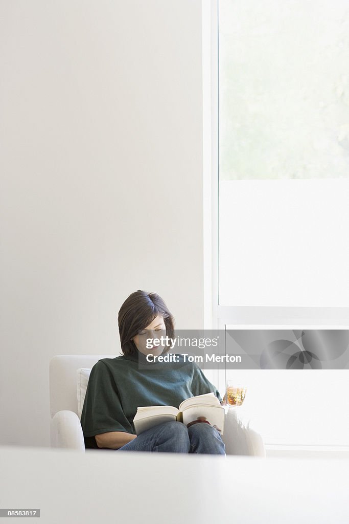 Mulher lendo na sala de estar