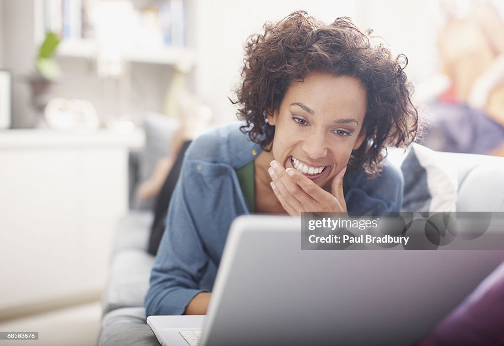 Woman using laptop on sofa