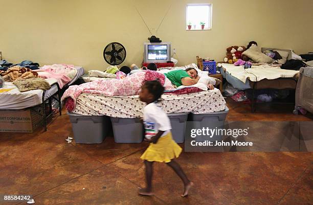 Homeless child runs past as homeless mother Carrie Wilson sleeps at the Presbyterian Night Shelter on June 19, 2009 in Ft. Worth, Texas. Wilson moved...