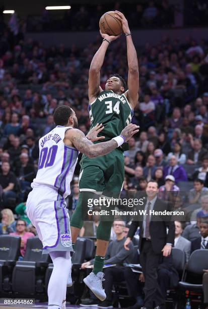 Giannis Antetokounmpo of the Milwaukee Bucks shoots over Willie Cauley-Stein of the Sacramento Kings during their NBA basketball game at Golden 1...