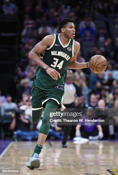 Giannis Antetokounmpo of the Milwaukee Bucks dribbles the ball up court against the Sacramento Kings during their NBA basketball game at Golden 1...